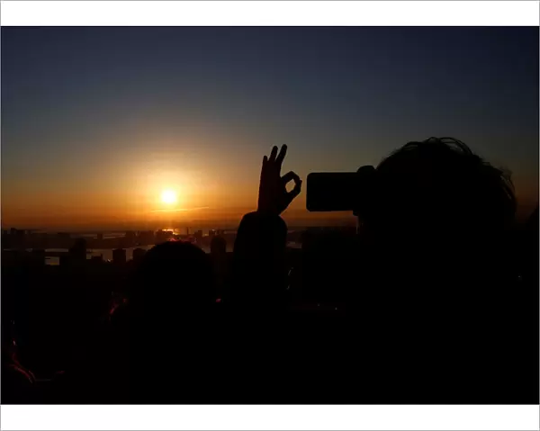 A man takes picture of the first sunrise on New Years Day at Roppongi Hills observation