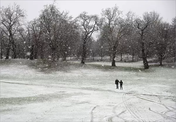 Pedestrians walk through the snow in Greenwich Park, London