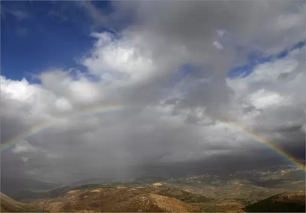 A rainbow stretches over Mount Haramoun as seen from the southern Lebanese village