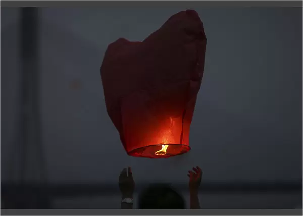 People release paper lanterns during a celebration for the New Year of the Dai minority
