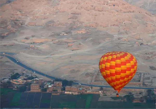 A hot-air balloon flies over the village of al-Qurna, situated over a necropolis of