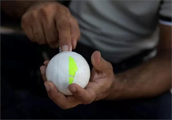 A Pakistani man living in Greece wraps a tennis ball in electrical tape before a tape-ball