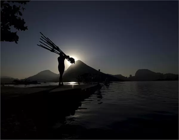 A rowing athlete carries paddles ahead of training session at the World Rowing Junior
