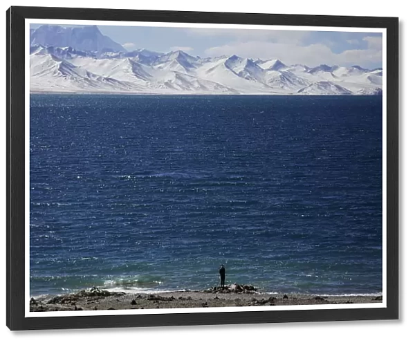 A Tibetan man stands at shores of Namtso lake in the Tibet Autonomous Region