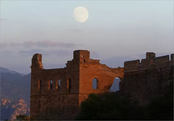 THE MOON RISES BEHIND A GUARD TOWER ON THE JIN SHAN SECTION OF THE GREAT WALL