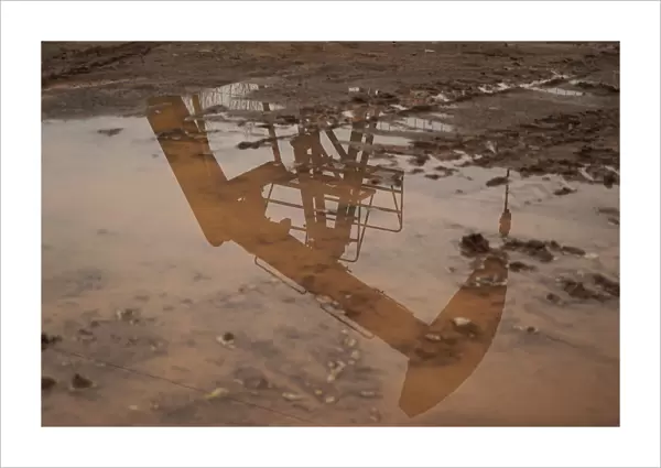 Coalbed methane well is seen reflected in a puddle in Jincheng