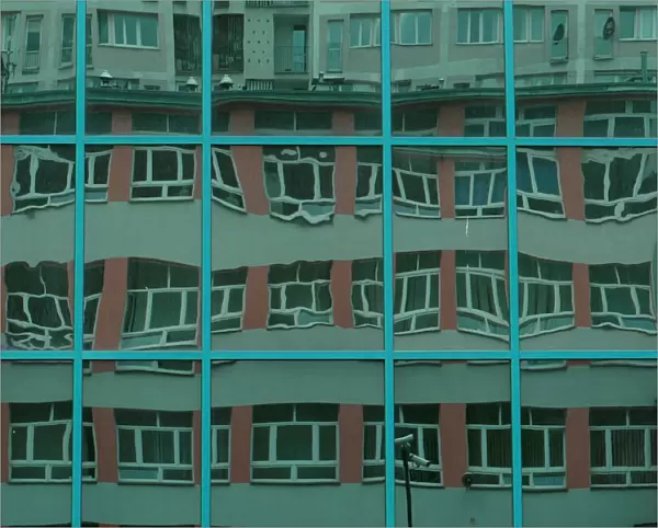 FILE PHOTO: Block of flats is reflected in the windows of an office building in Warsaw