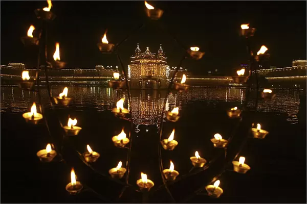 Illuminated holy Sikh shrine of Golden temple is seen through decoration of oil lamps