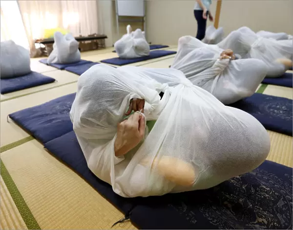 Participants perform Otonamaki, which translates as adult wrapping