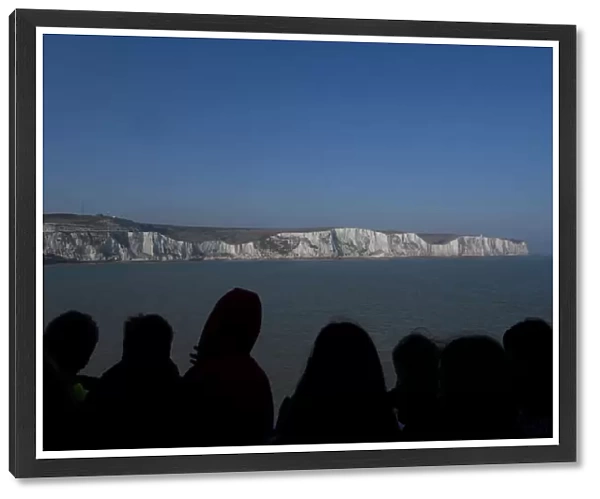 Passengers view the white cliffs of Dover from a cross-channel ferry between Dover in