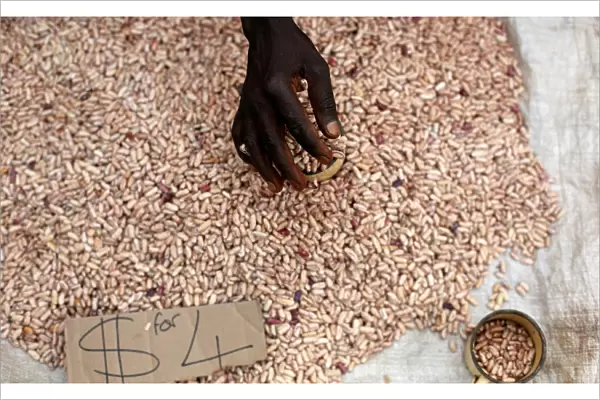 A street vendor sorts through beans in Harare, Zimbabwe