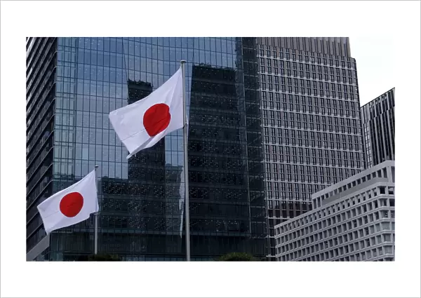 Japanese national flags flutter in front of buildings at Tokyos business district