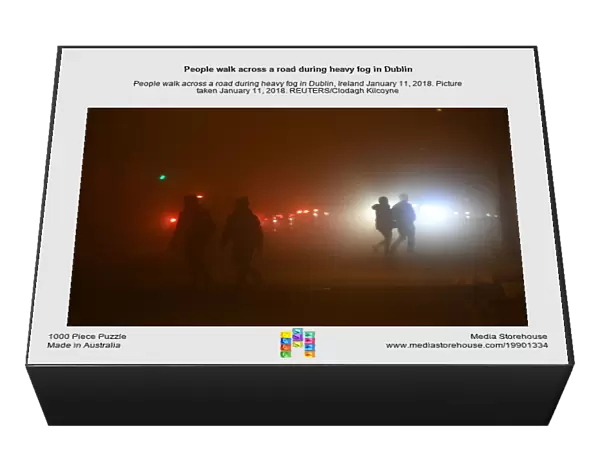 People walk across a road during heavy fog in Dublin