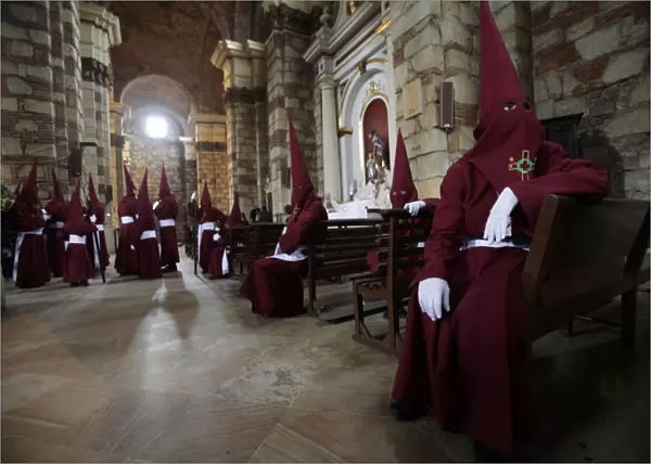 Members of the Nazarenos brotherhood rest inside a church during a Holy Week procession