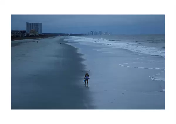 A woman looks for shells ahead of the arrival of Hurricane Florence in Surfside Beach
