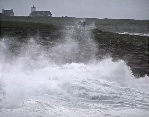 People watch waves breaking on the Brittany coast as storm Eleanor approaches Esquibien