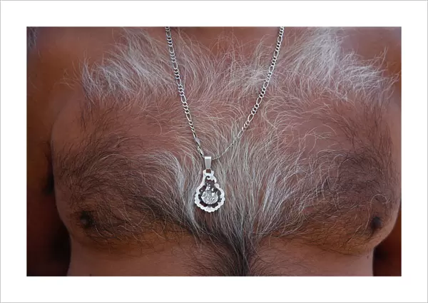 A man wears a pendant of the traditional Virgen del Carmen one day before arrival of