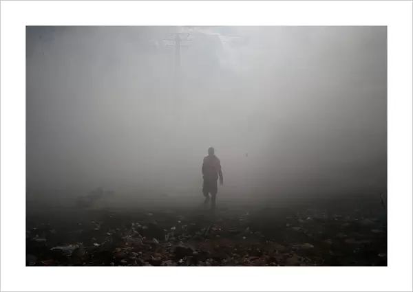 A Palestinian medic walks as tear gas was fired by Israeli troops during clashes near the