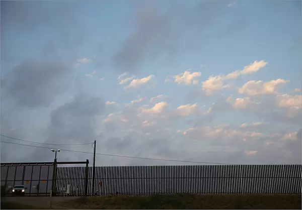 A U. S. Border Patrol agent guards a section of border fence by the Mexico-U. S