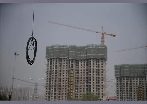 A cable is seen near residential buildings under construction in Beijing