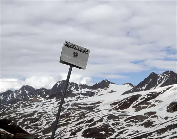 A sign marks the border between Italy and Austria at the alpine pass Hochjoch in the