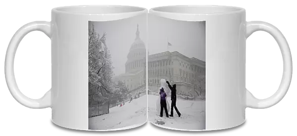 People build a snowman outside the U. S. Capitol in Washington