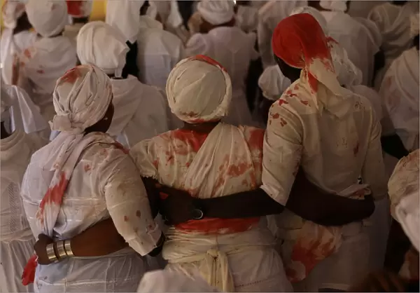 Worshippers with stains of goats blood on their clothes participate in a ceremony during