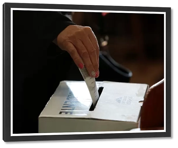 A voter casts her ballot during the presidential election at a polling station in San