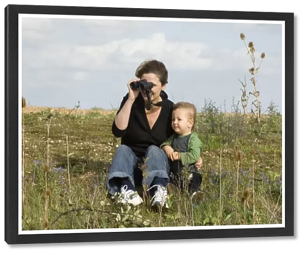 Mother and toddler looking at birds on a windy day at Snettisham RSPB Reserve North