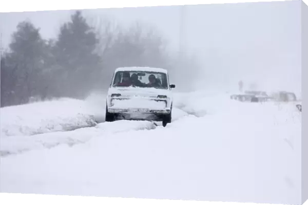 Car travelling along snow covered road during blizzard on route to Kazbegi Great