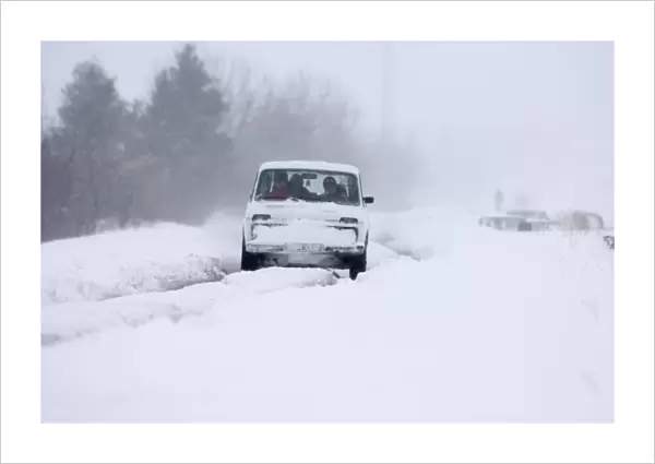 Car travelling along snow covered road during blizzard on route to Kazbegi Great