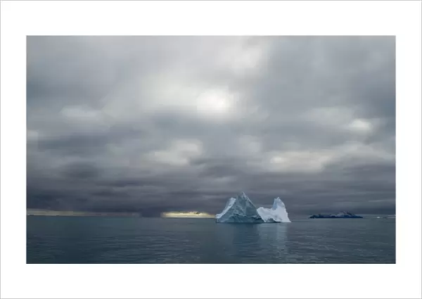 Iceberg and in distance Annekov Island off the rarely visited south west coast of