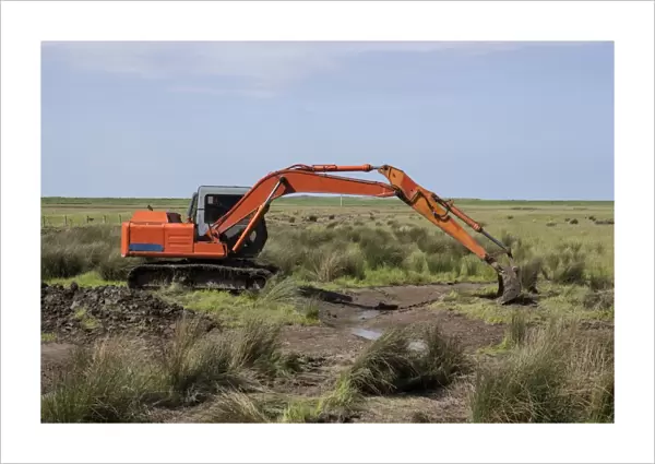 Using a digger excavator for habitat restoration work on Deepdale Marsh, Burnham Deepdale, North Norfolk