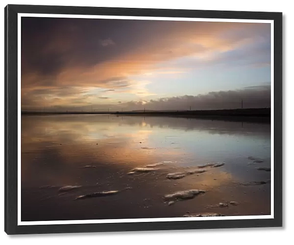 View of clouds reflected in mud at sunrise, Oare Creek, Oare, Faversham, North Kent, England, January