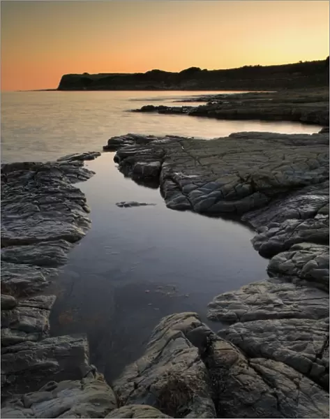 View of rockpool on beach at sunset, Hobarrow Bay, Isle of Purbeck, Dorset, England, july