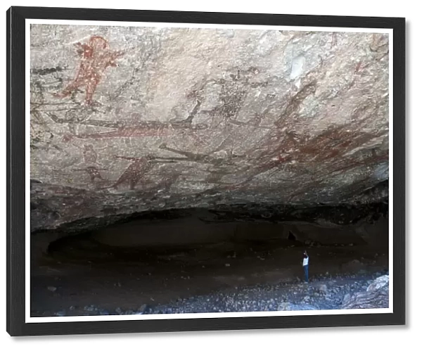 Tourist looking at San Borjitas cave paintings, oldest cave paintings in western hemisphere, circa 7500 years old