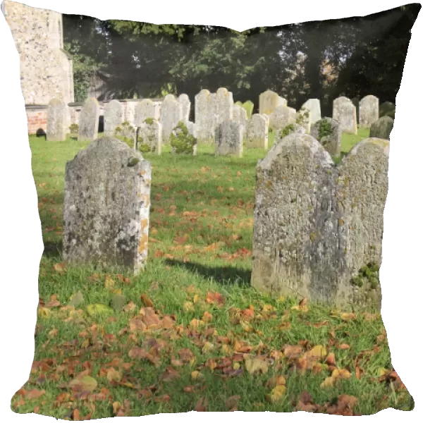 Headstones in church graveyard, with fallen leaves on grass, St. Marys Church, Mendlesham, Suffolk, England, november