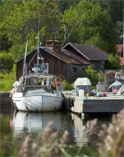 Fishing boat moored at jetty in fishing village, Bonan, Gastrikland, Norrland, Baltic Sea, Sweden, august