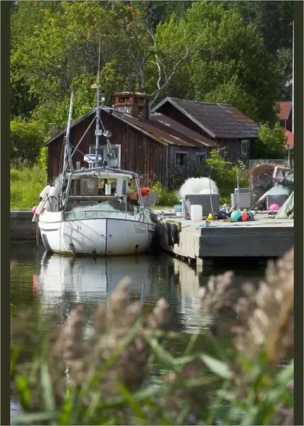 Fishing boat moored at jetty in fishing village, Bonan, Gastrikland, Norrland, Baltic Sea, Sweden, august