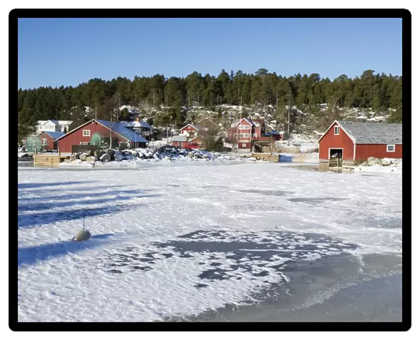 View of fishing village with boathouses in ice and snow, Bonan, Gastrikland, Norrland, Baltic Sea, Sweden, february