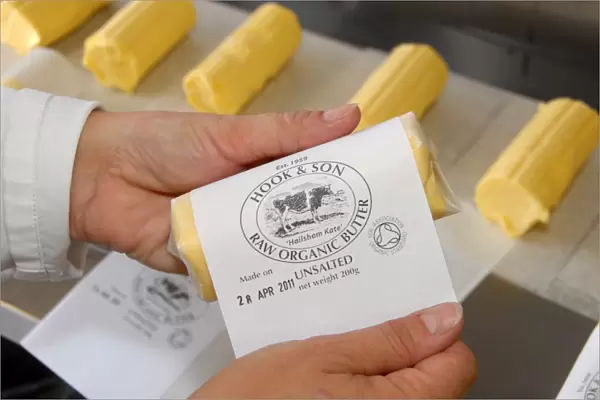 Worker labelling up organically made butter from unpasteurized milk, on organic dairy farm, Hook and Son