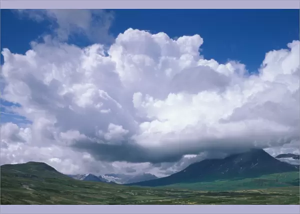 North America, Canada, Yukon Territory summer clouds over mountains near Haines