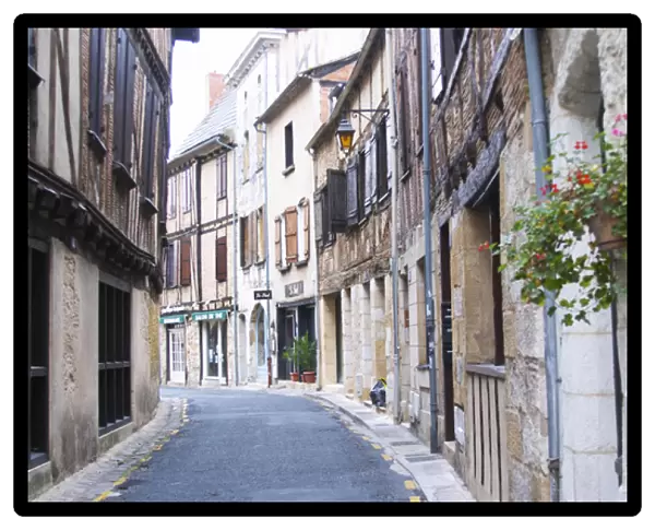 A curving street in the old town with old stone and wooden beam houses. Bergerac