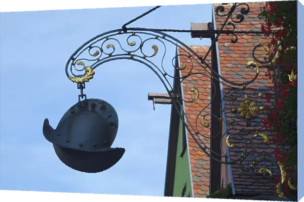 Europe, Germany, Rothenburg. A medieval helmet sign hangs in front of an ironworks shop