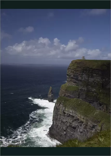 Distant scenic of the Cliffs of Moher and O Briens Tower under a blue sky