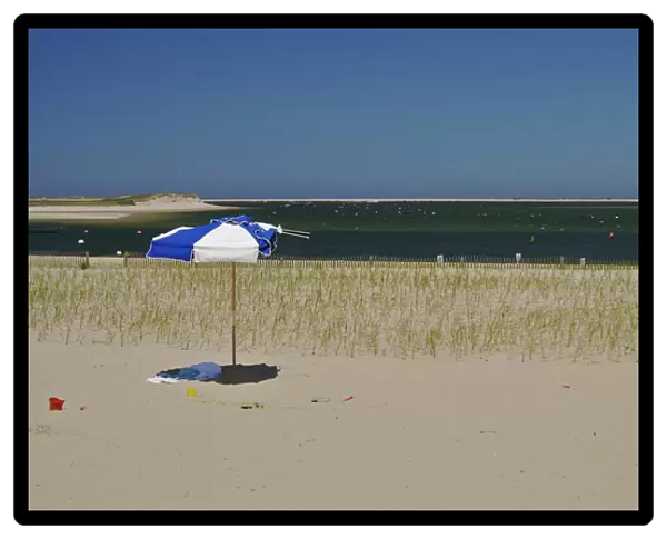 North America, USA, Massachusetts, Chatham. An umbrella and pails on the beach