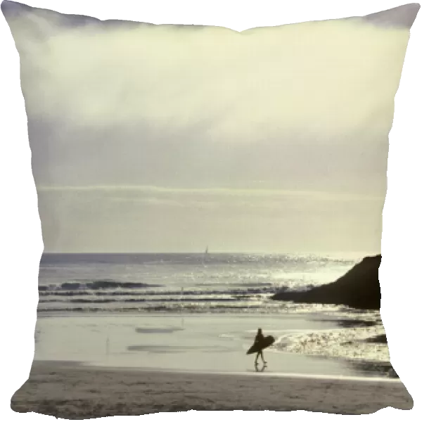 USA, Oregon, near Heceta Head, lone surfer going out into the Pacific Ocean