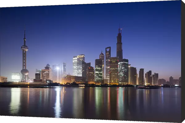China, Shanghai, Glow of twilight behind towering skyline of Pudong district along