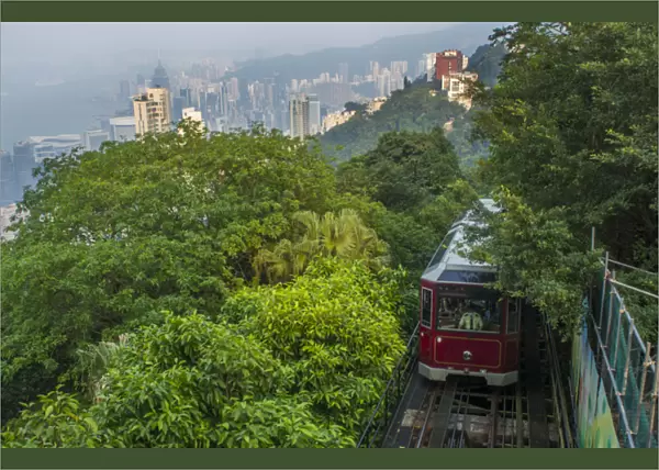 Hong Kong China Victoria Peak Tram going down mountain on smoggy hazy foggy day with