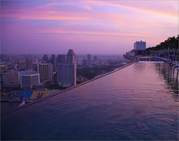 Singapore, Marina Bay Sands Hotel. Cantilevered hotel swimming pool at sunrise. Credit as